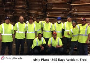 Several Quincy recycle workers celebrate safety wearing yellow safety clothing in Alsip, IL.