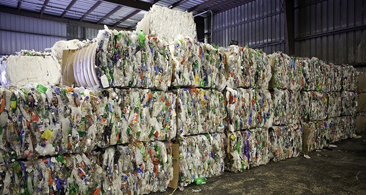 Large bales of multi-color commingled plastic material.