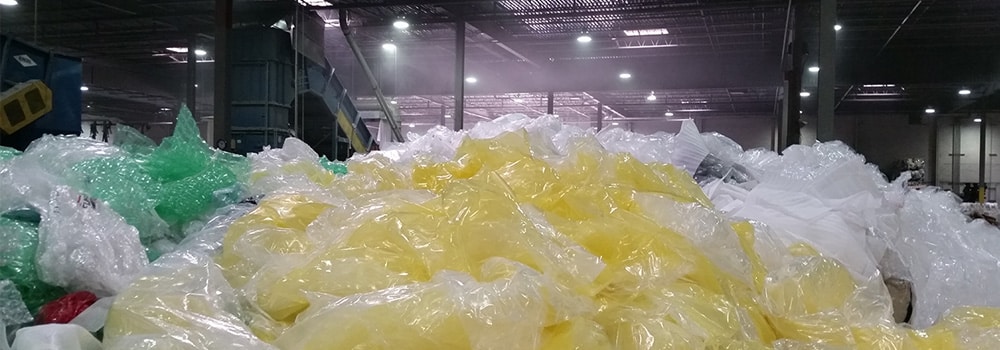 Large piles of green, yellow, and white plastic materials.