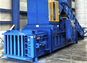Large blue horizontal baler used for processing recycled materials.