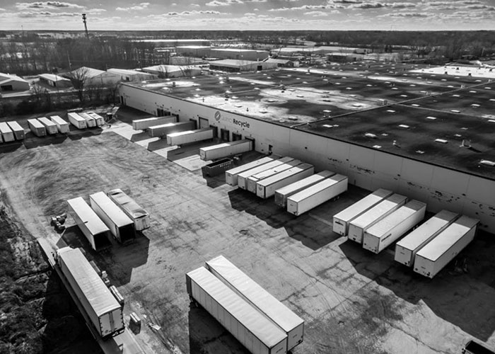 About us: Aerial view of a large Quincy Recycle location with several trailers parked at loading docks.