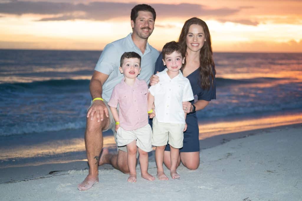 Picture of Nate McNally, his wife and two children at the beach.